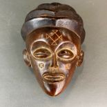 An early 20th century African carved hardwood mask, H. 24cm.