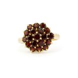 A 9ct yellow gold cluster ring set with round cut garnets, (P).