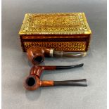 An inlaid box and three vintage tobacco pipes.