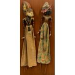 A pair of Indonesian puppets mounted on a board, 46 x 93cm.