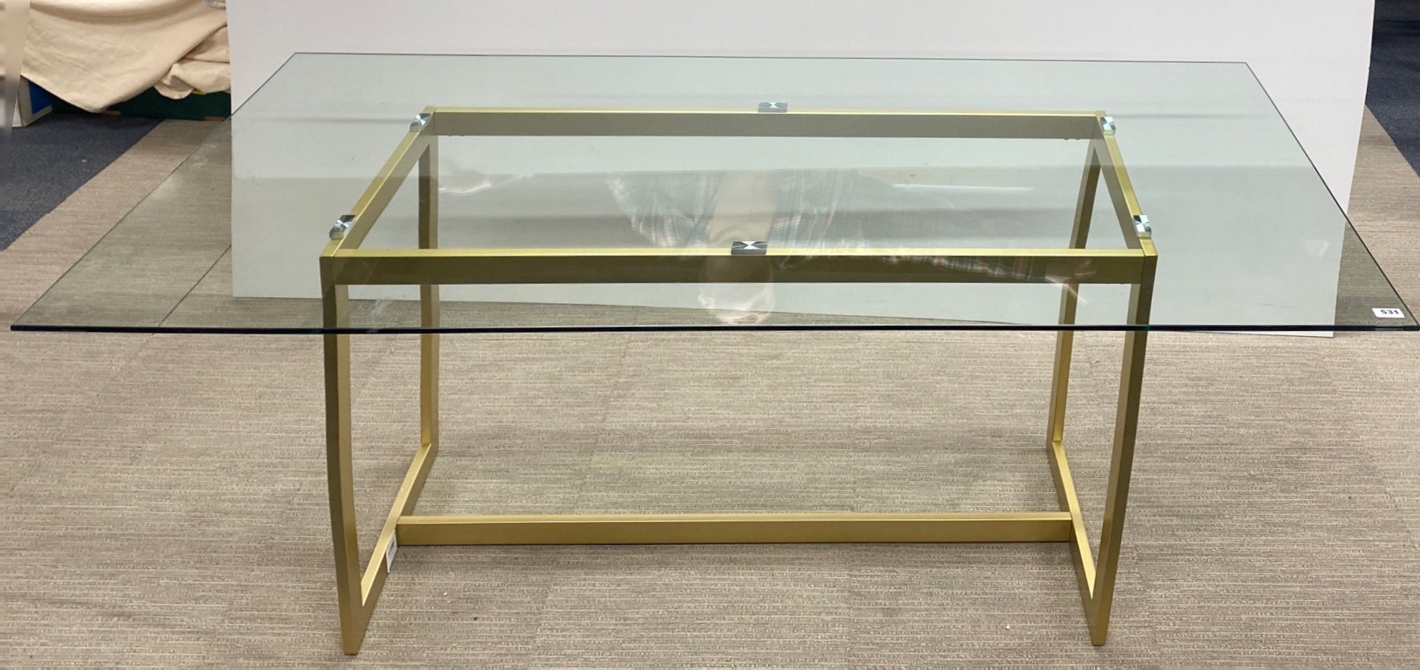 A contemporary heavy plate glass top and gilt metal base dining table, 180 x 90cm.