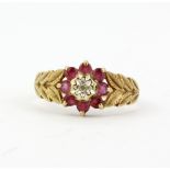 A hallmarked 9ct yellow gold ring set with round cut rubies and a diamond, (M.5).