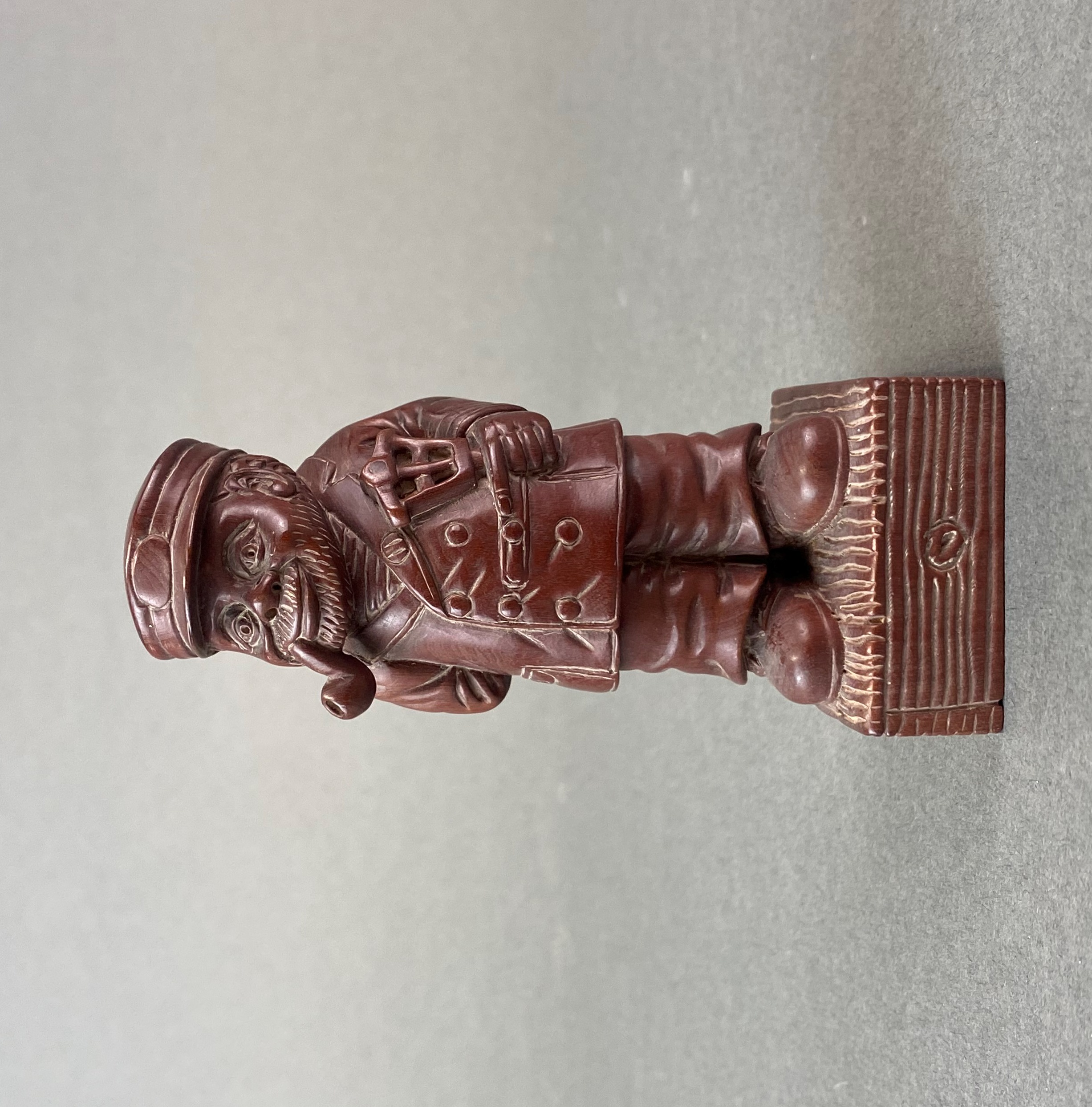 A carved fruitwood figure of a bearded gentleman smoking a pipe, H. 10cm.