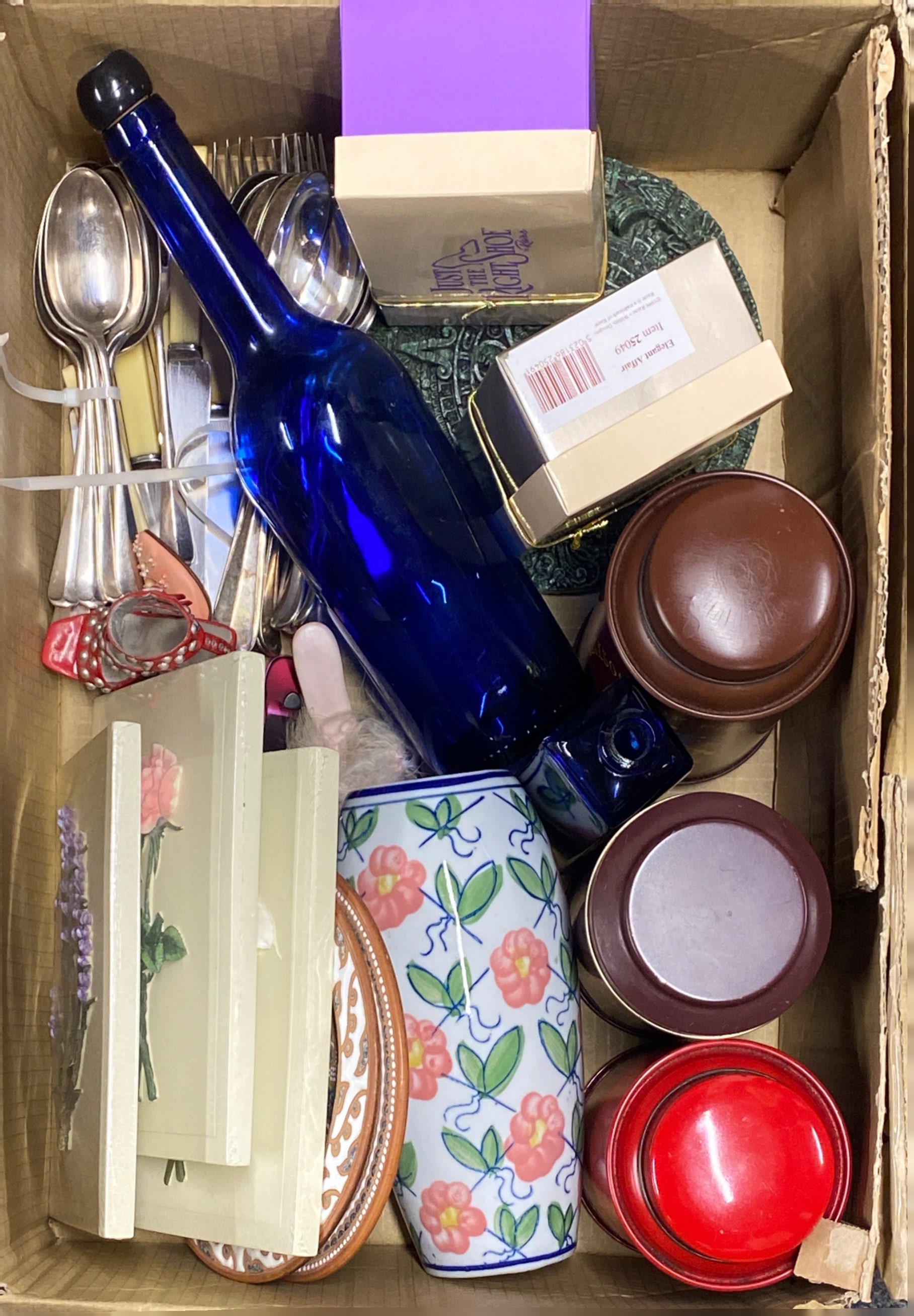 A box of mixed cutlery and other items.