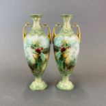 A fine pair of hand painted and gilt porcelain urns, H. 26cm.