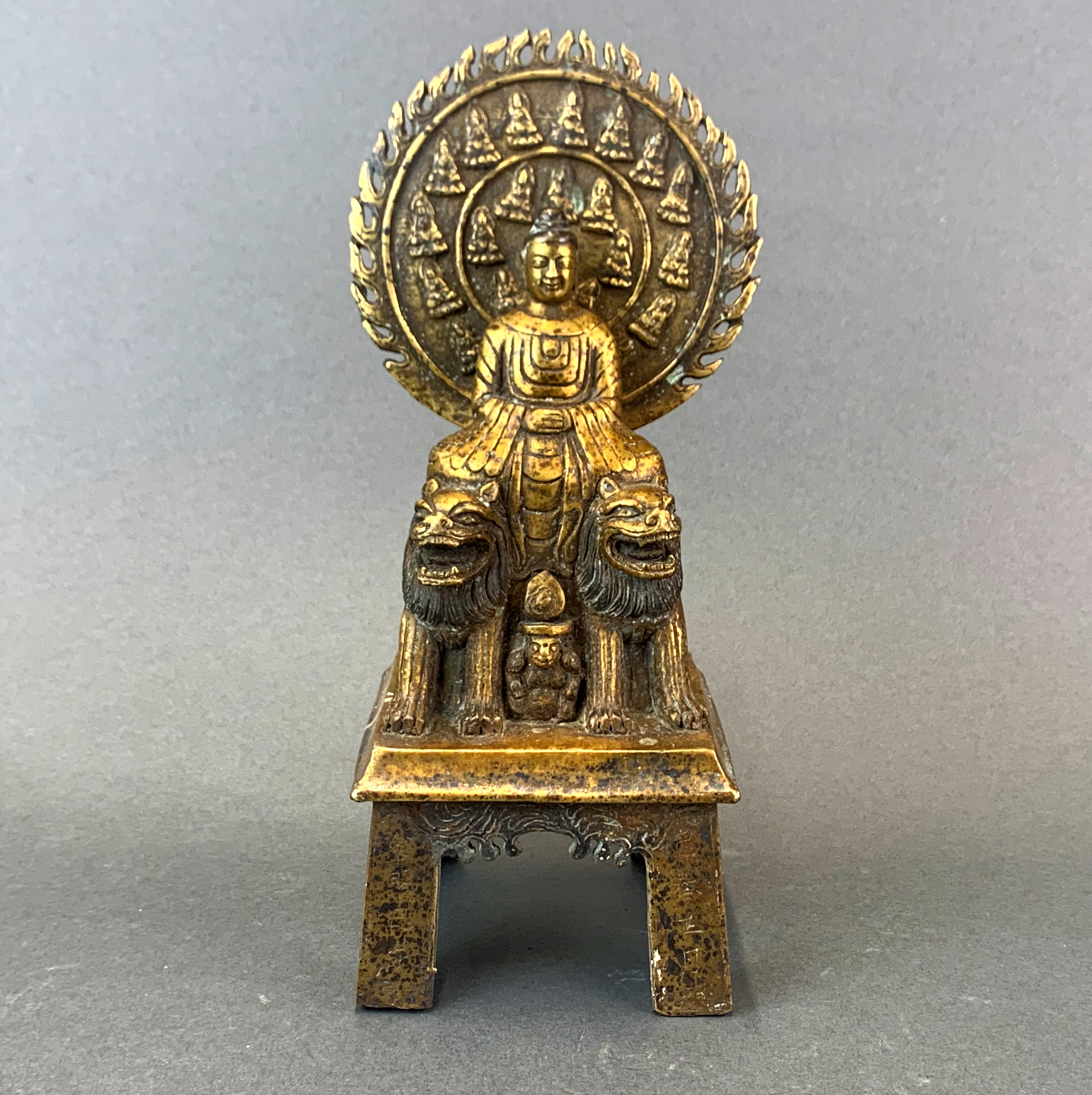 A Sino-Tibetan gilt bronze figure of the Buddha seated on two lions, H. 27cm.