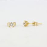 A pair of 18ct yellow gold stud earrings each set with a brilliant cut diamond, colour G, clarity