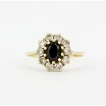 A 14ct yellow gold cluster ring set with an oval cut black stone and white stones, (P).