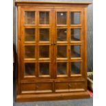 A useful glazed pine cabinet, W. 141cm. H. 180cm.
