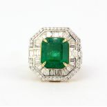 An 18ct yellow and white gold ring set with a large cushion cut emerald, 1.2 x 0.9cm, surrounded