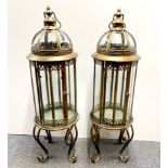 A pair of metal and glass storm lanterns, H. 83cm.