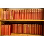 A collection of cloth bound volumes of classic literature.