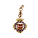 A 9ct yellow gold enamelled Essex County Senior Challenge Cup medal, c. 1920-21, with 9ct chain.