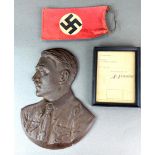 A cast iron wall mounted bust of Adolf Hitler with two further items.