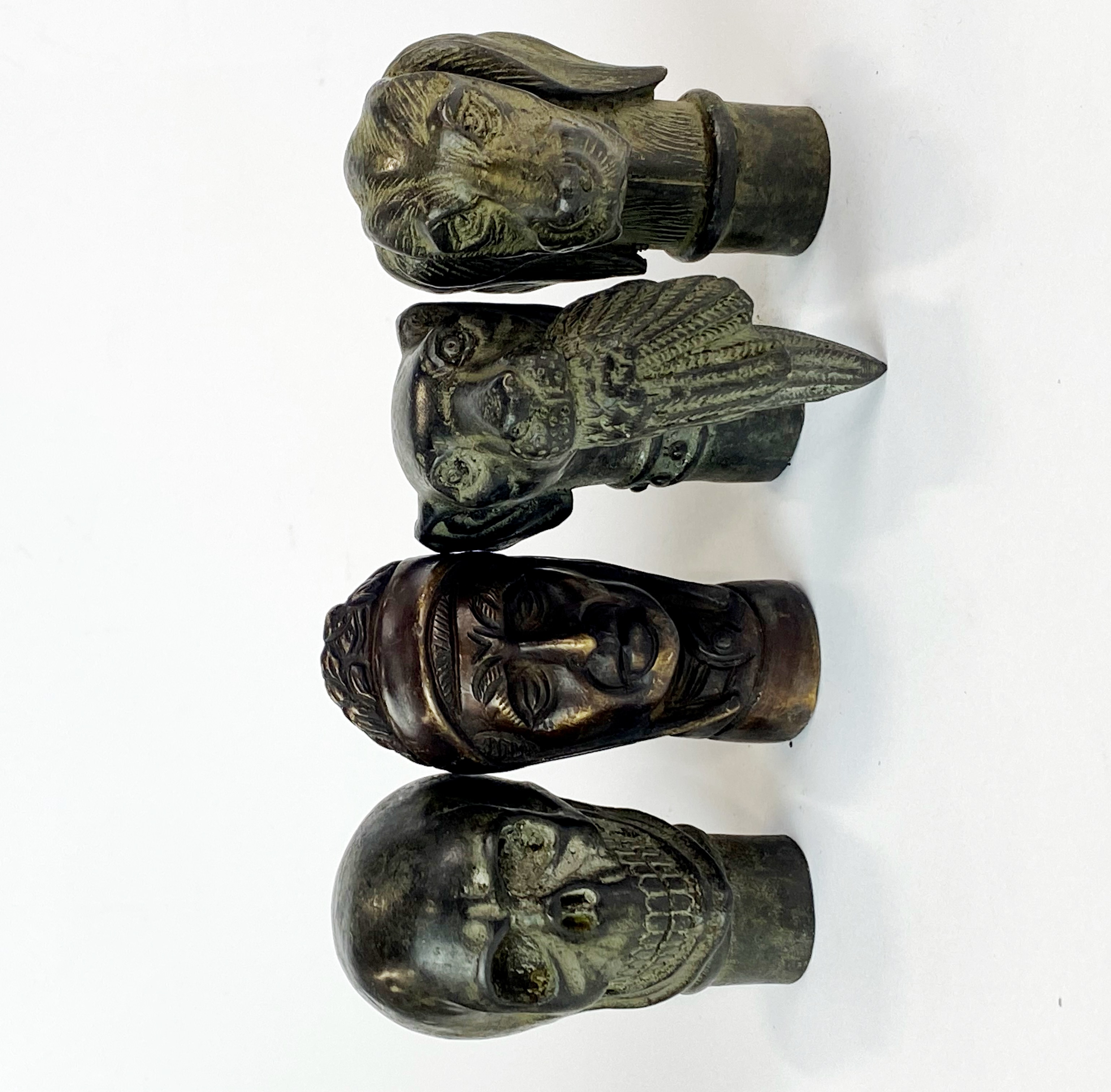 A group of four bronze walking stick handles, H. 7cm.