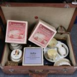 A vintage suitcase containing a quantity of Belleek and other porcelain.