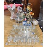 A glass chess set with a group of other glassware and three cast iron door stops.