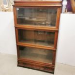 A 20th C barristers three section oak bookcase with glass sliding doors and a single bottom