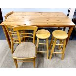 A pine kitchen table, 86 x 150cm, with three kitchen chairs and two stools.
