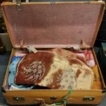 A vintage suitcase and mixed fabric contents.