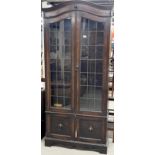 A 1920's carved oak bookcase with leaded glass doors, W. 93cm. H. 201cm.