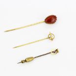 A group of two 9ct gold and one yellow metal stone set stick pins, longest L. 7.5cm.