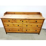 A large pine chest of drawers together with a matching pair of pine chests of drawers and a