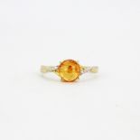 A hallmarked 9ct yellow gold ring set with a cabochon heliodor and diamonds, (M).