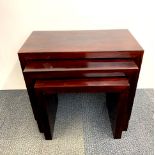 A nest of three hardwood veneered side tables, largest 49 x 60 x 30cm, some minor chips to the