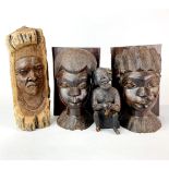 A pair of African figured ebony book ends together with a further carved face and a pottery