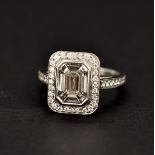An white metal (tested minimum 18ct gold) ring set with a large emerald cut diamond surrounded by