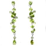 A pair of 925 silver long drop earrings set with mixed cut peridots, L. 5cm.