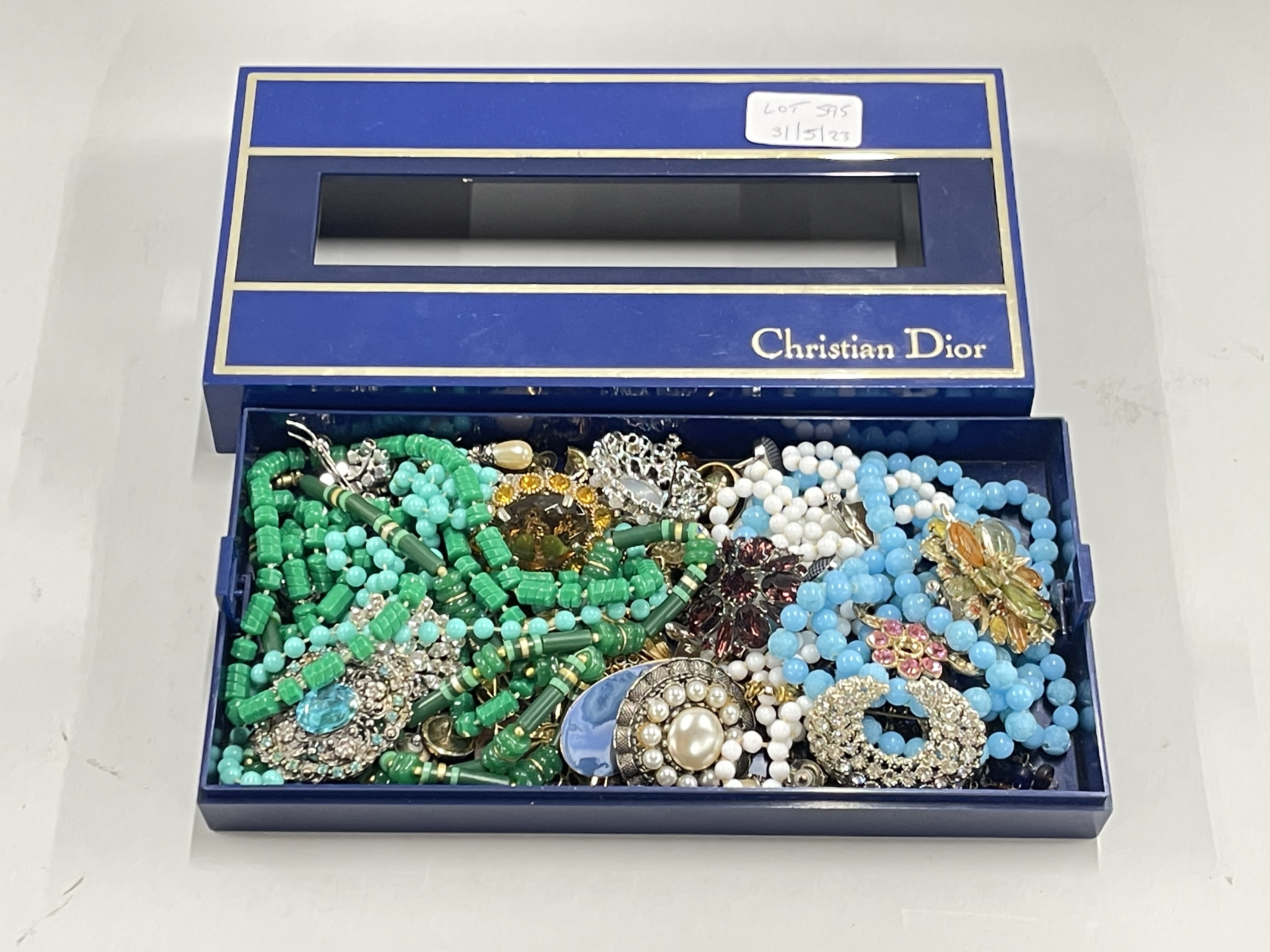 A Christian Dior tissue box cover containing a quantity of costume jewellery.