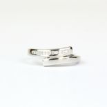 A 9ct white gold diamond set crossover ring, (M.5).