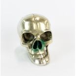 A silvered bronze/brass skull with articulated jaw, H. 9.5cm, d. 12cm.