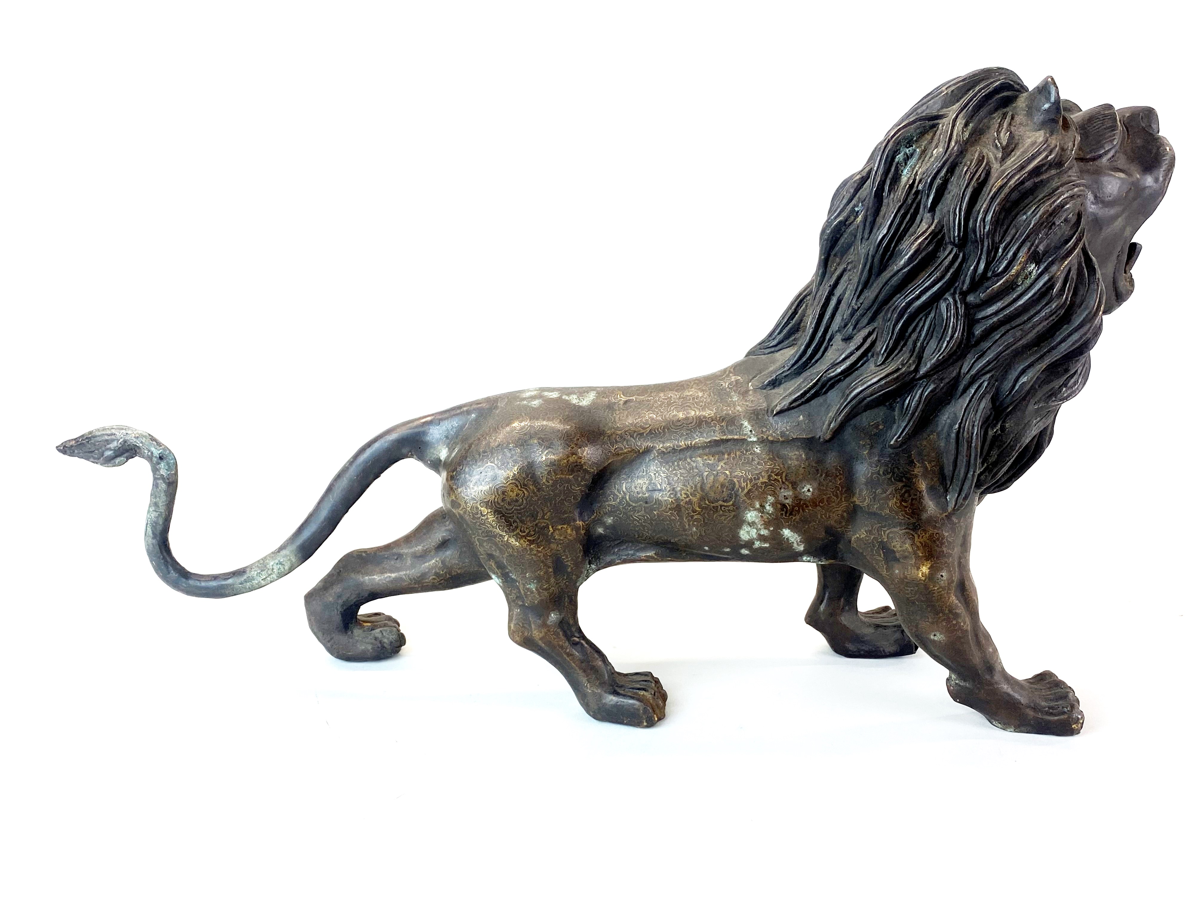 A large bronze figure of a roaring lion with interesting surface decoration, H. 31cm, L. 56cm. - Image 4 of 4