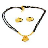 A high carat yellow gold (tested approx. 20ct) black beaded necklace, L. 41cm, together with a