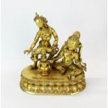 A Tibetan gilt bronze figure of a Buddhist celebration, H. 28cm, W. 28cm.