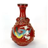 An unusual Chinese relief decorated and hand painted porcelain vase featuring a dragon on one side
