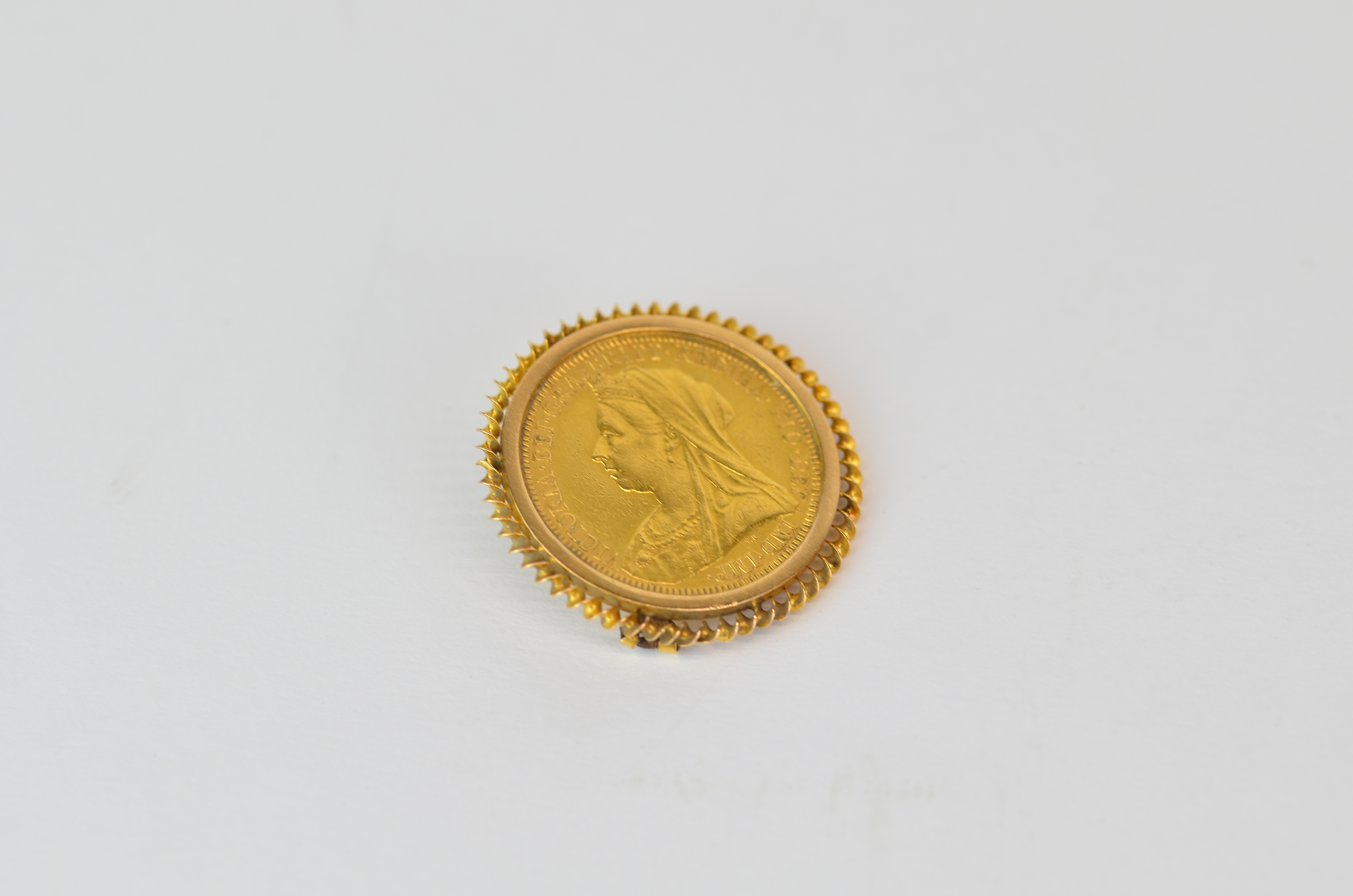 An 1894 full sovereign in a 9ct gold brooch mount, missing bar.