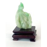 A small Chinese carved jade figure of a bird sitting on a branch, H. 6.5cm, With later stand.