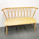 An Ercol light elm two seater spindle cross back settle. L. 112cm, H. 83cm.