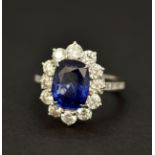 An 18ct white gold cluster ring set with a large cushion cut sapphire, approx. 4.52ct, L. 1.2cm,