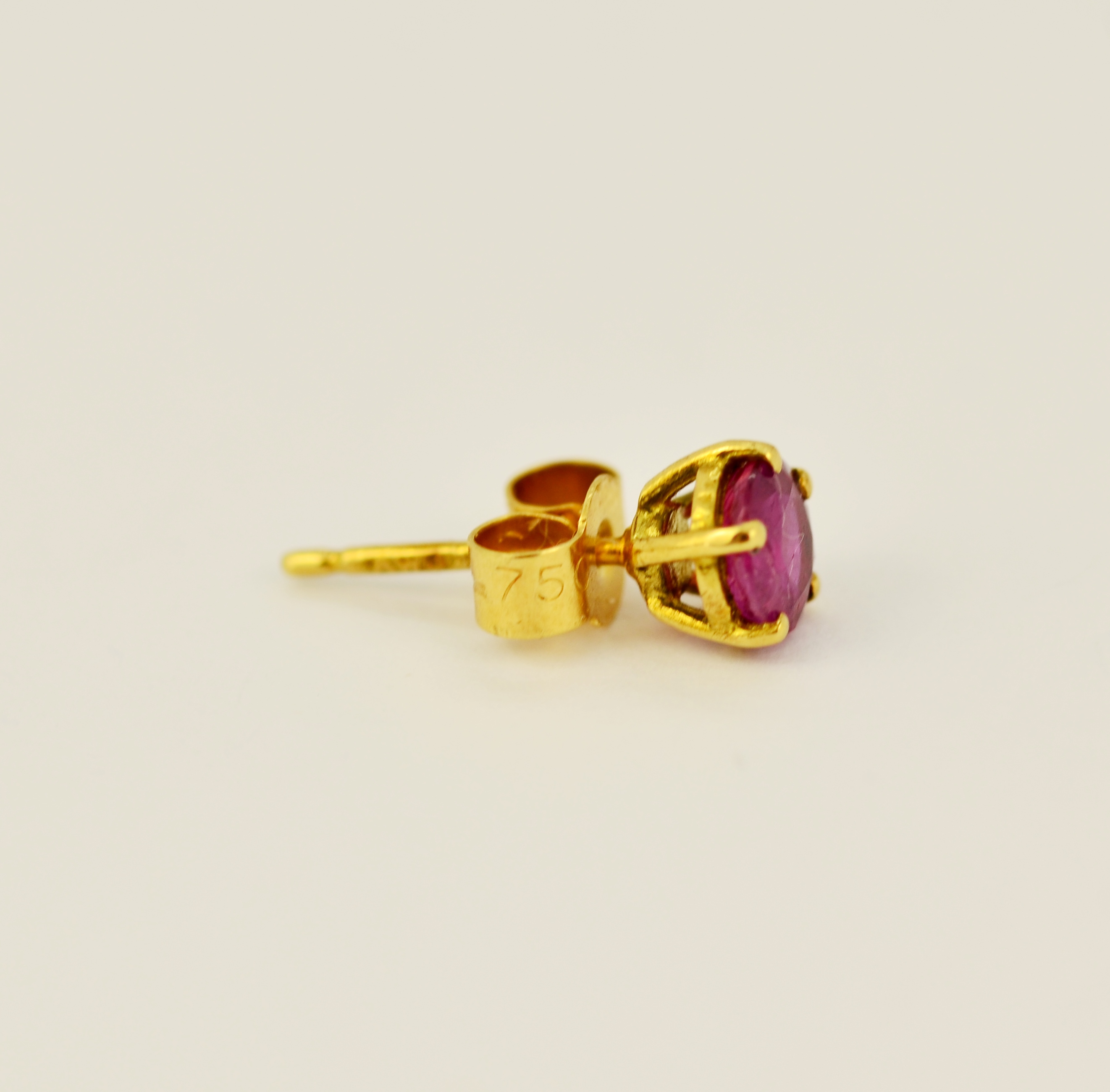 A pair of hallmarked 18ct yellow gold stud earrings set with round cut rubies, L. 0.5cm. - Image 3 of 3