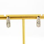 A pair of 9ct white gold earrings set with princess and brilliant cut diamonds, L. 1.3cm.