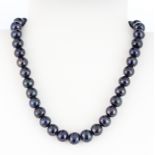 A black freshwater pearl necklace with a white metal clasp, L. 40cm. Pearl Dia. 11mm.