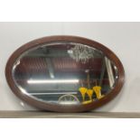 An Edwardian oval inlaid mahogany wall mirror, W. 90cm.