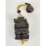 A carved wooden Japanese Buddha shaped inro with sack netsuke, inset mother of pearl signature to