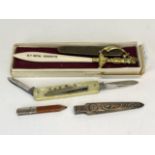 An RMS Queen Mary pen knife with a further pen knife, letter opener and pencil holder.
