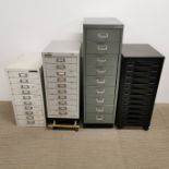 Three Bisley metal filing cabinets, one attached to platform with castors, together with a further